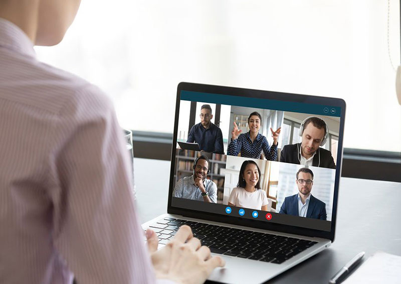 A person is on the computer with several people in front of them.